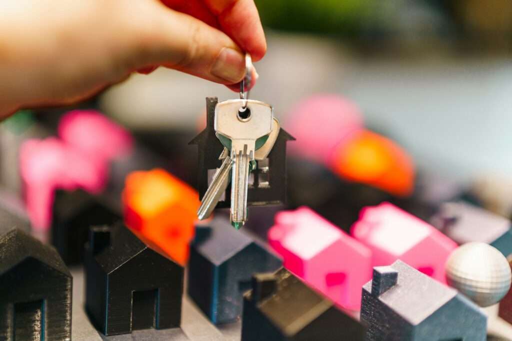 Hands exchanging house keys at the close of a real estate transaction, representing closing day for a home seller in British Columbia